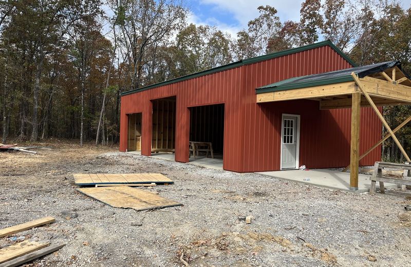 A red metal shop building with the roof complete